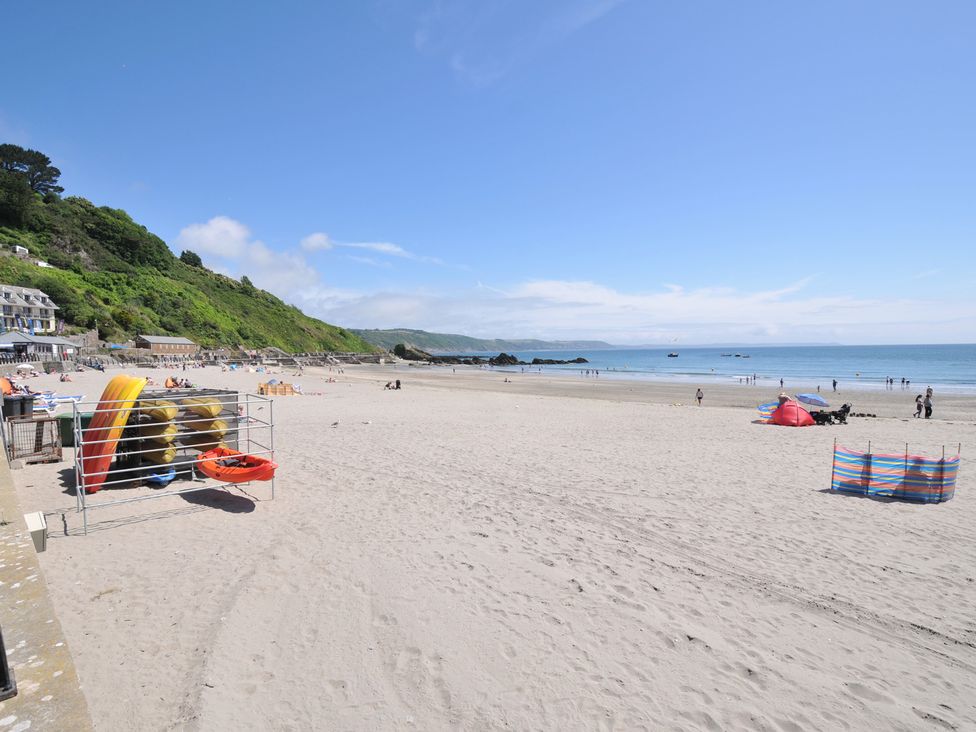 A beach with people and surfboards at 3 River View in Looe