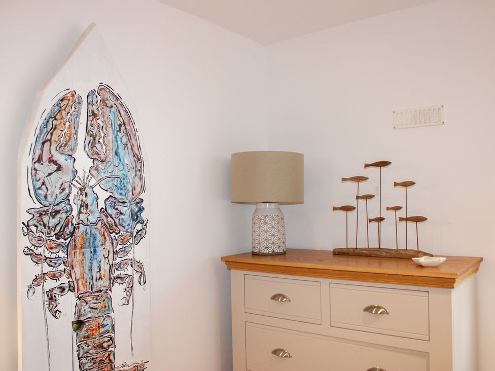 A living room with a lobster art piece and decorative lamp at 5 Harbour Yard in Salcombe
