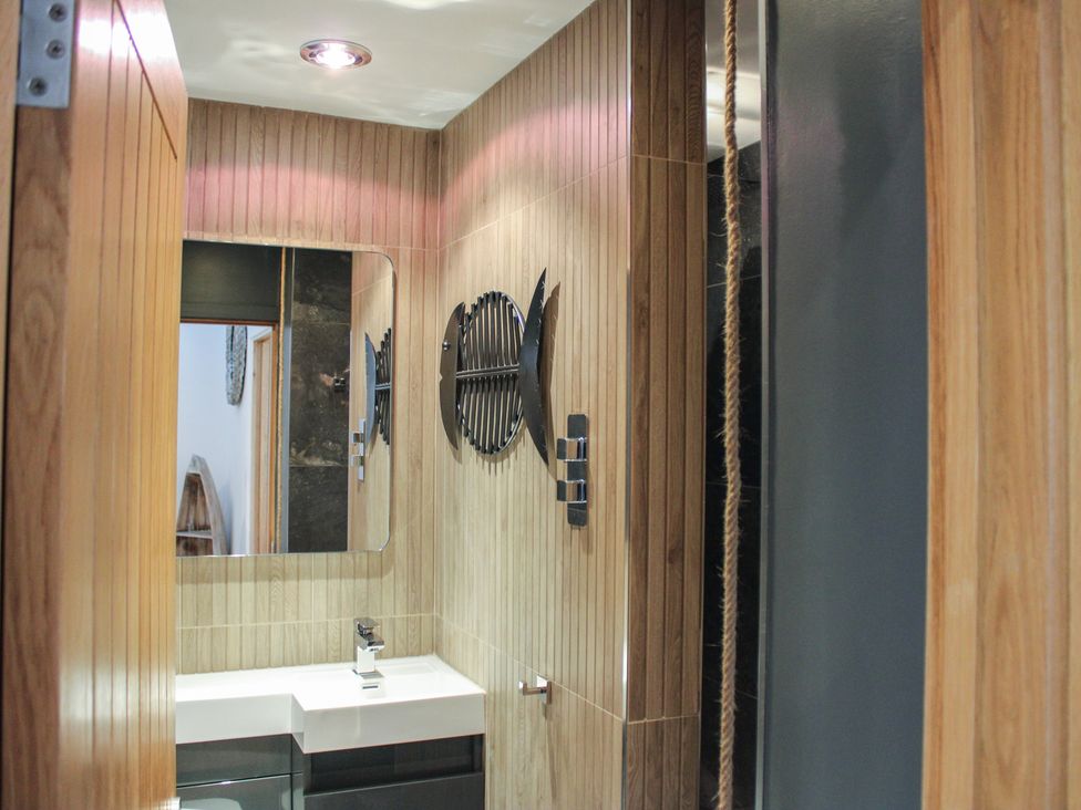 A bathroom with a sink and mirror at 5 Harbour Yard in Salcombe