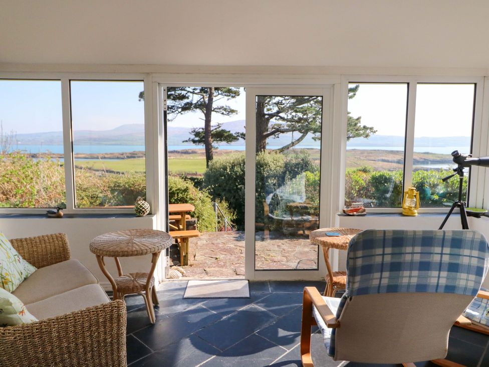 A sunroom with seating and a view at Whispering Pines in Durrus, County Cork