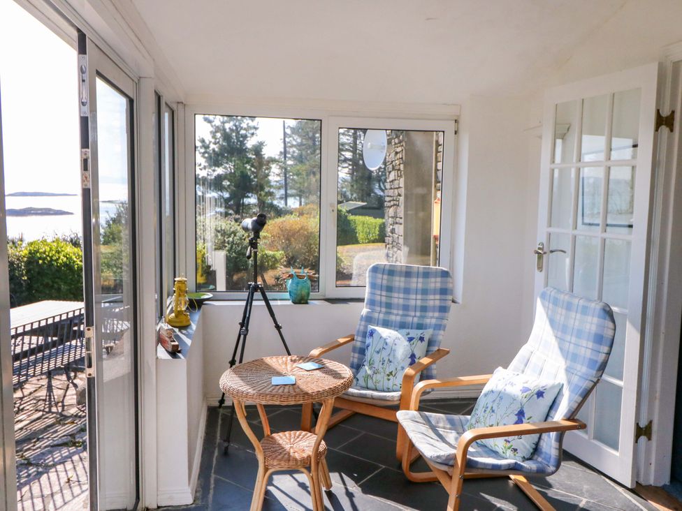 A conservatory with chairs and a table at Whispering Pines in Durrus, County Cork