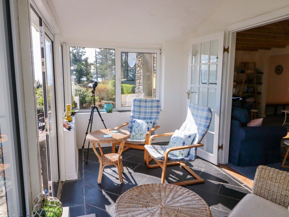 A conservatory with chairs and a table at Whispering Pines in Durrus, County Cork