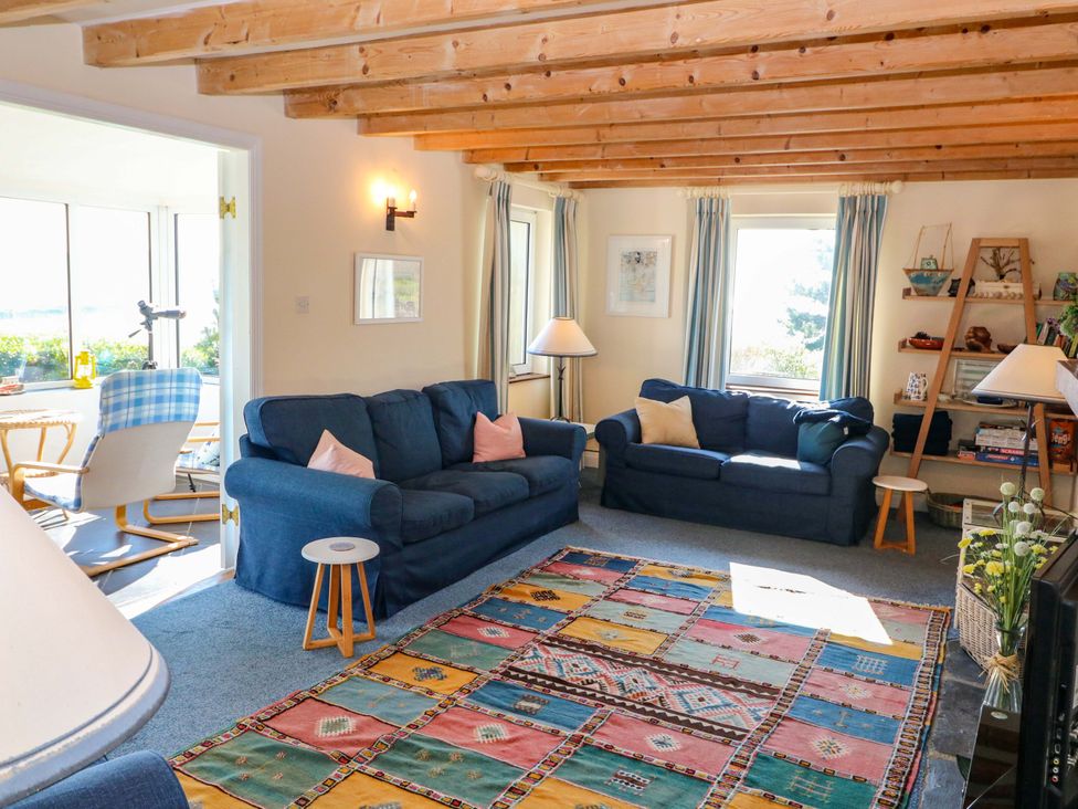A living room with two sofas and a rug at Whispering Pines in Durrus, County Cork