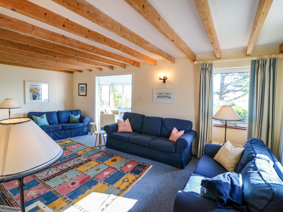 A living room with blue sofas and a lamp at Whispering Pines in Durrus, County Cork
