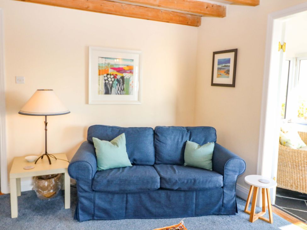 A living room with a blue sofa and lamp at Whispering Pines in Durrus, County Cork