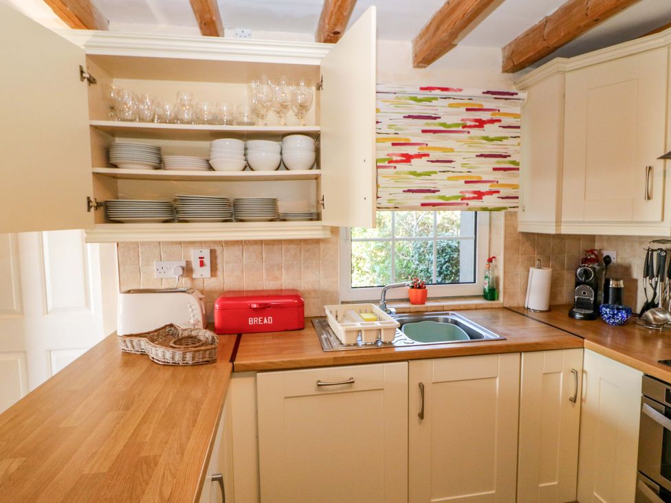 A kitchen with shelves of dishes and a sink at Whispering Pines in Durrus, County Cork