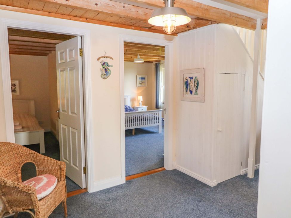 A hallway with a staircase and doorway to a bedroom at Whispering Pines in Durrus, County Cork