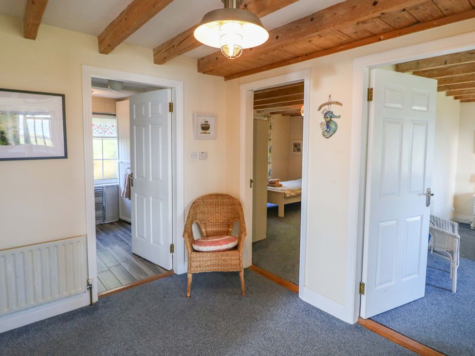 A hallway with doors and a chair at Whispering Pines in Durrus, County Cork