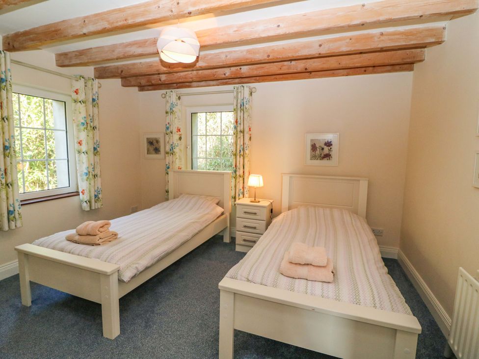 A bedroom featuring two single beds and a nightstand at Whispering Pines in Durrus, County Cork
