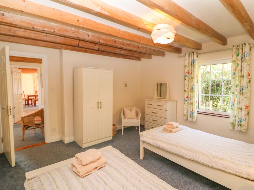 A bedroom with two beds and a wardrobe at Whispering Pines in Durrus, County Cork