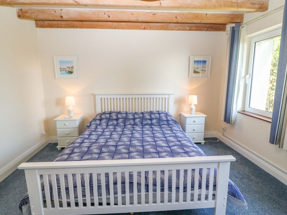 A bedroom with a bed and bedside tables at Whispering Pines in Durrus, County Cork