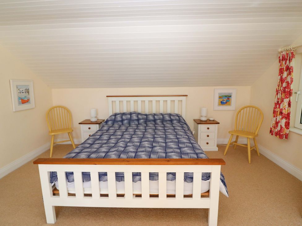 A bedroom with a bed and nightstands at Whispering Pines in Durrus, County Cork