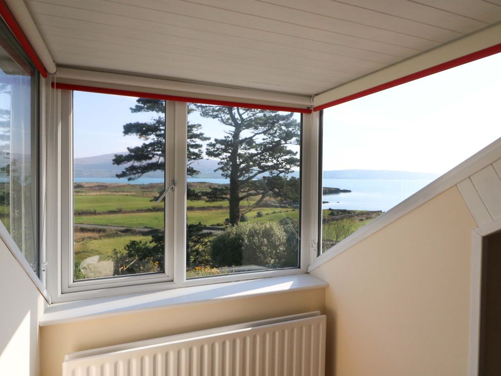 A window with a view of trees and water at Whispering Pines in Durrus, County Cork