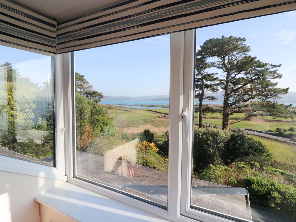 A view from a window showing trees and a landscape at Whispering Pines in Durrus, County Cork
