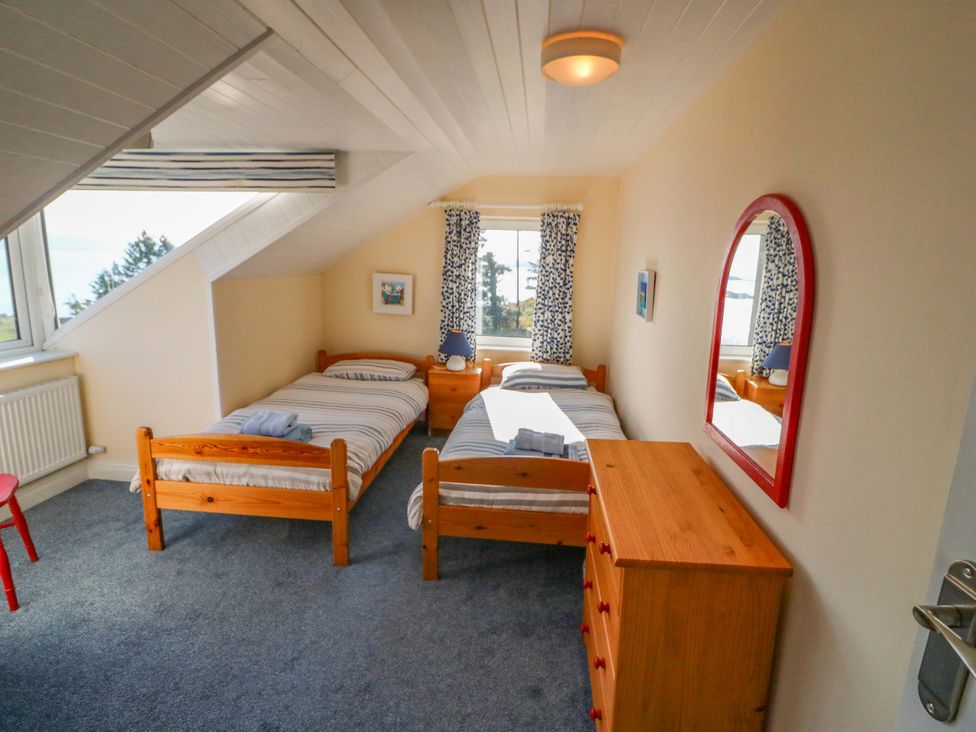 A bedroom with two beds and a dresser at Whispering Pines in Durrus, County Cork