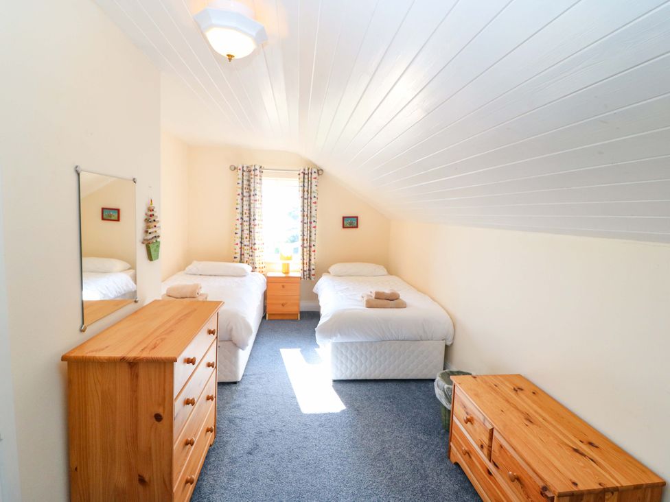 A bedroom with two beds and a dresser at Whispering Pines, Durrus, County Cork
