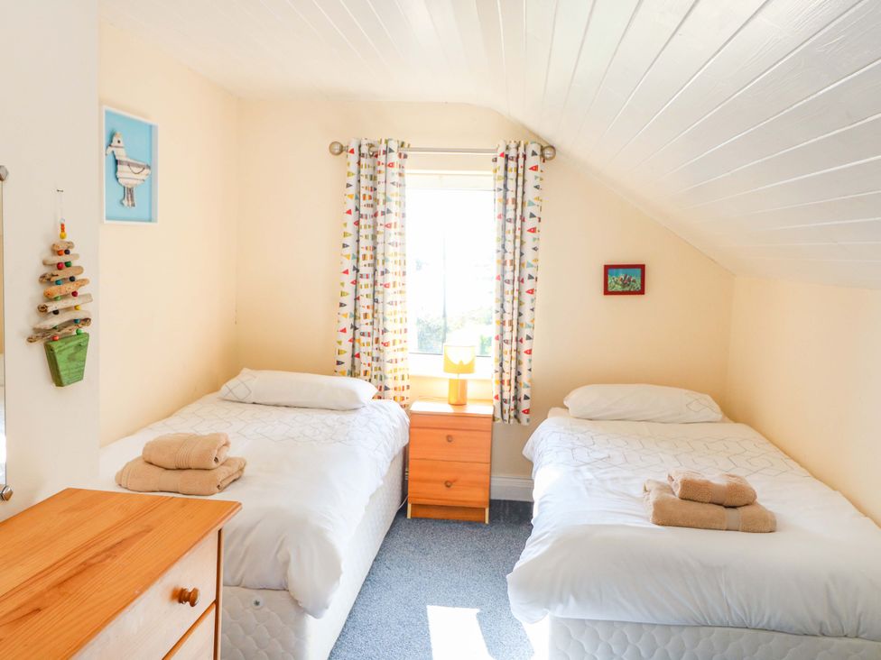 A bedroom with two beds and a window at Whispering Pines in Durrus, County Cork