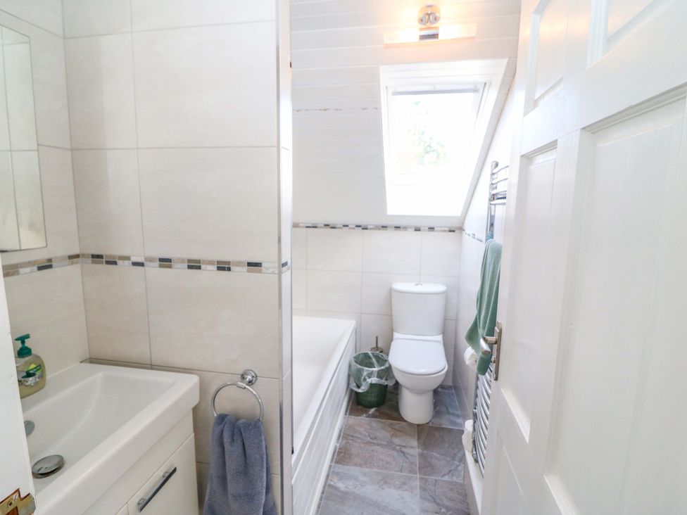 A bathroom with sink, toilet, and bathtub at Whispering Pines, Durrus, County Cork