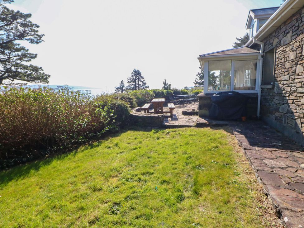 An outdoor area with a table and chairs near a house at Whispering Pines in Durrus, County Cork