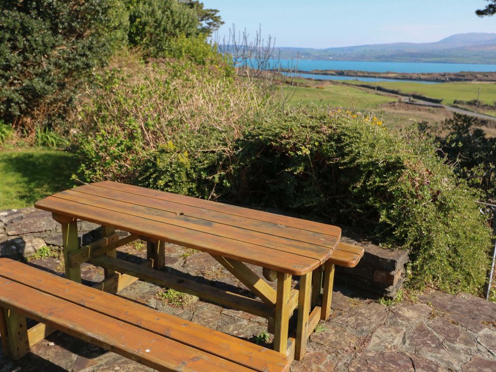 A wooden table and benches overlooking water at Whispering Pines in Durrus, County Cork