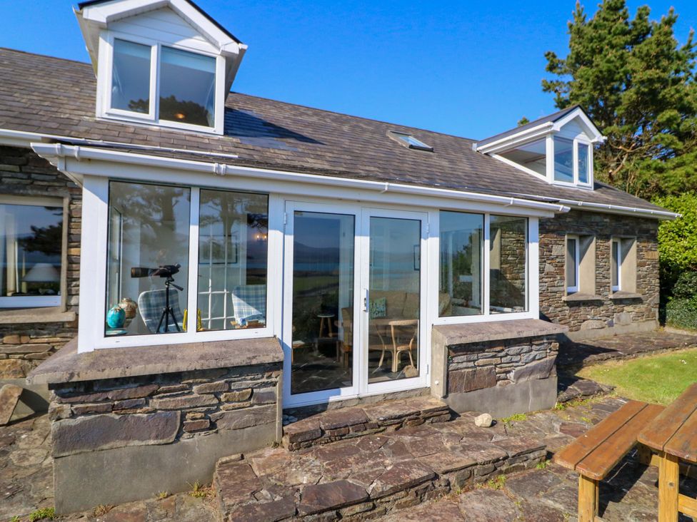 A conservatory with glass windows and a door at Whispering Pines in Durrus, County Cork