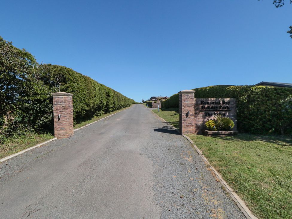A road lined with hedges leading to a sign at Lilac Lodge Runswick Bay near Staithes