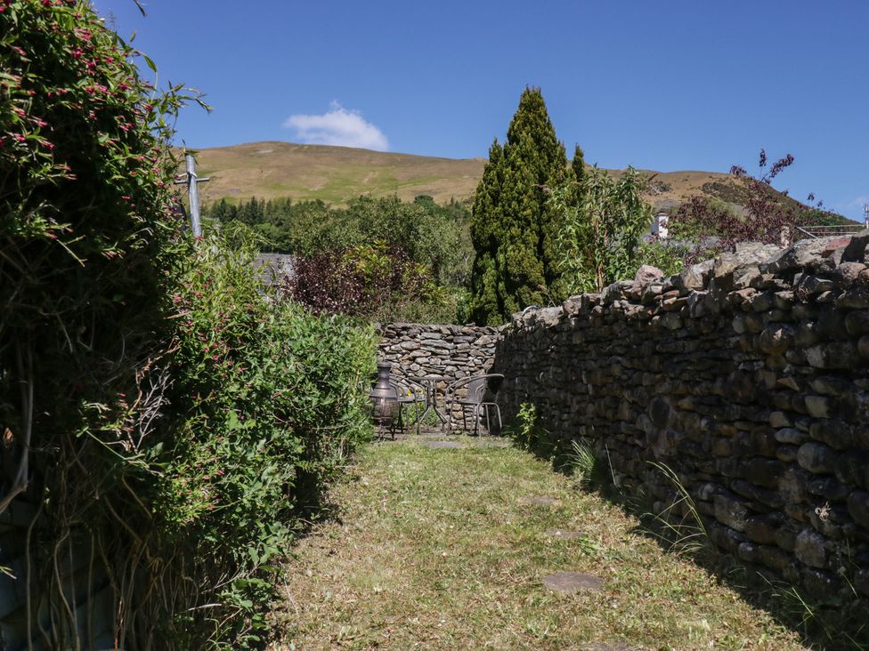 A garden path with stone walls and seating area at Badgers, Sedbergh, Yorkshire Dales