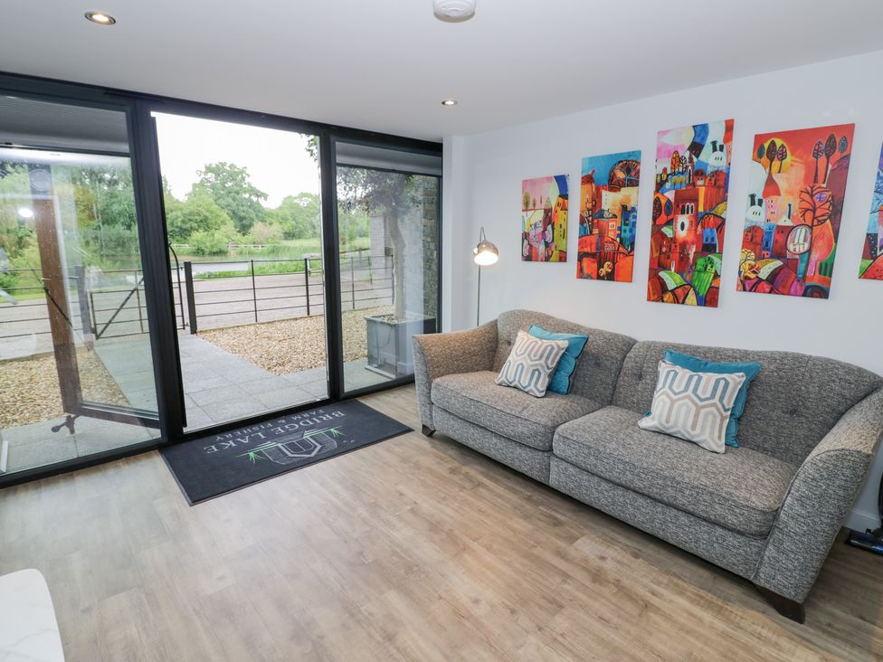 A snug with a sofa and artwork on the wall at The Tunnel at Bridge Lake Farm and Fishery Chacombe