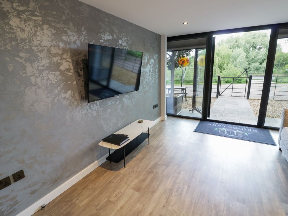 A living room with a television and a table at The Tunnel at Bridge Lake Farm and Fishery Chacombe