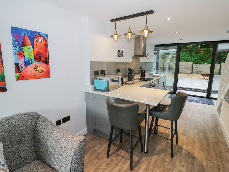 A kitchen with stools and a counter at The Tunnel at Bridge Lake Farm and Fishery Chacombe