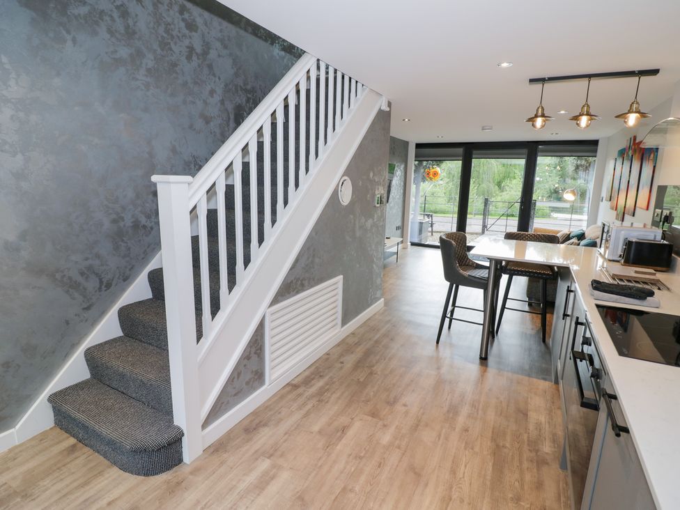 A kitchen with stairs and bar stools at The Tunnel at Bridge Lake Farm and Fishery Chacombe