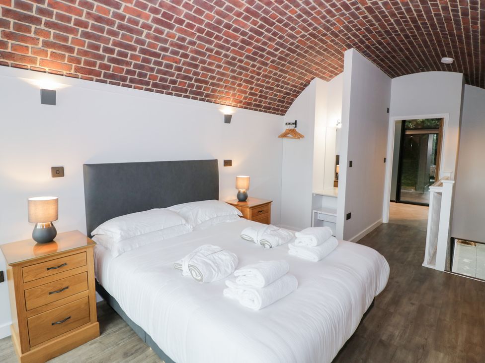 A bedroom with a bed and bedside tables at The Tunnel at Bridge Lake Farm and Fishery Chacombe