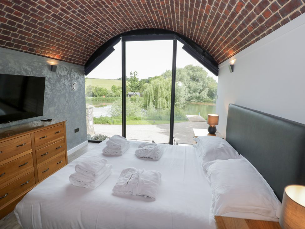 A bedroom with a bed and television at The Tunnel at Bridge Lake Farm and Fishery Chacombe