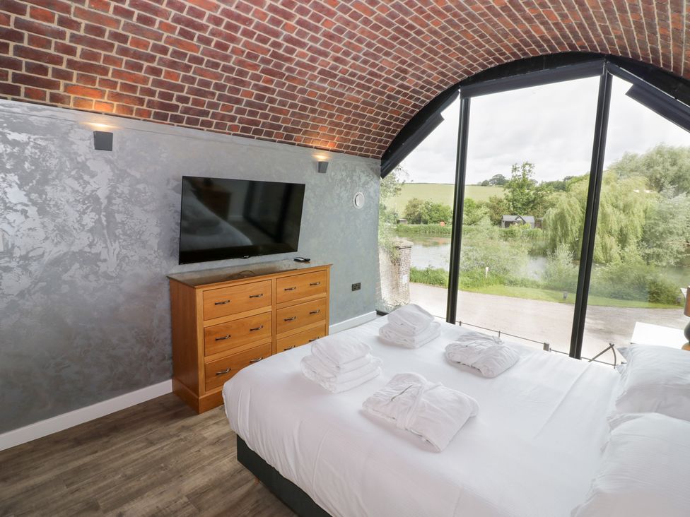 A bedroom with a bed and television at The Tunnel at Bridge Lake Farm and Fishery Chacombe