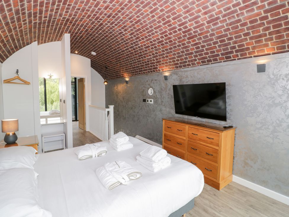 A bedroom with a bed and television at The Tunnel at Bridge Lake Farm and Fishery Chacombe