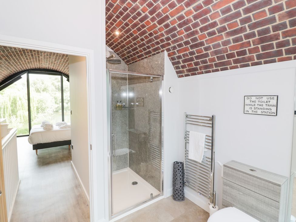 A bathroom with a shower and toilet at The Tunnel at Bridge Lake Farm and Fishery Chacombe