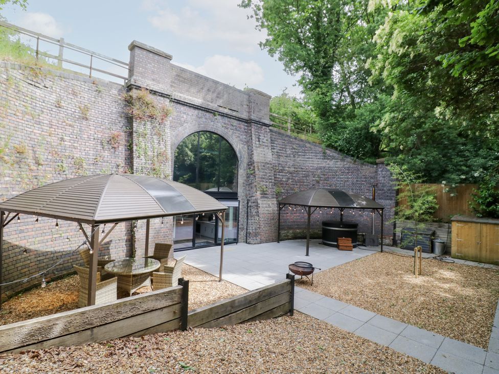 A garden with gazebos and seating at The Tunnel at Bridge Lake Farm and Fishery in Chacombe
