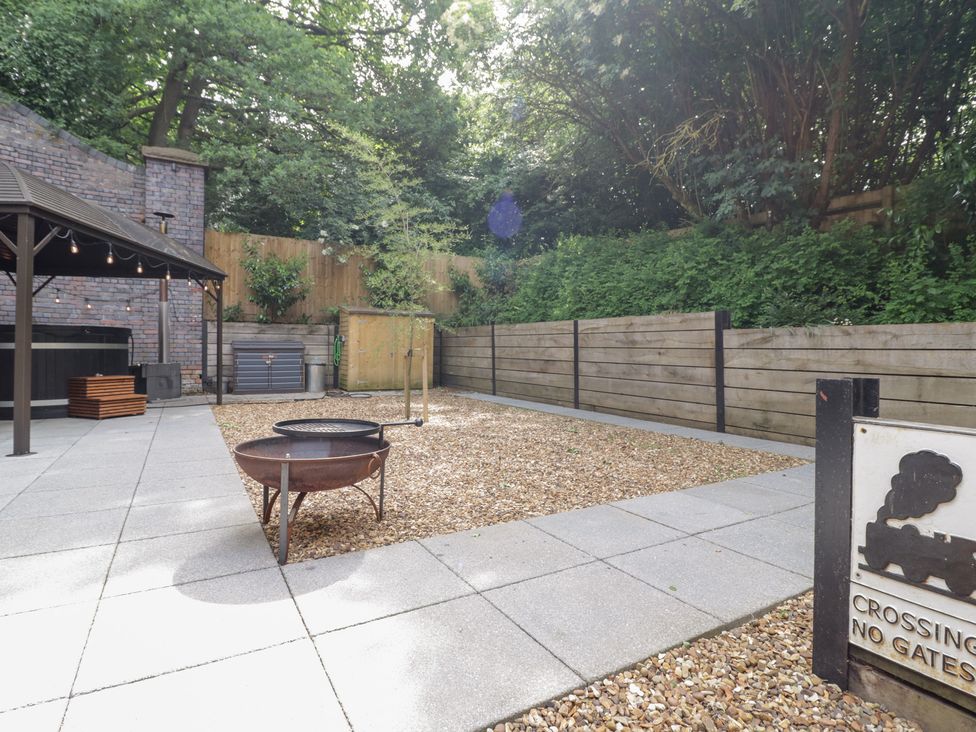 A garden with a fire pit and wooden fence at The Tunnel at Bridge Lake Farm and Fishery Chacombe