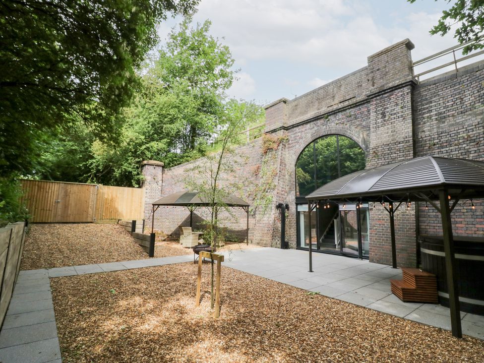An outdoor area with gazebos and a brick wall at The Tunnel at Bridge Lake Farm and Fishery Chacombe