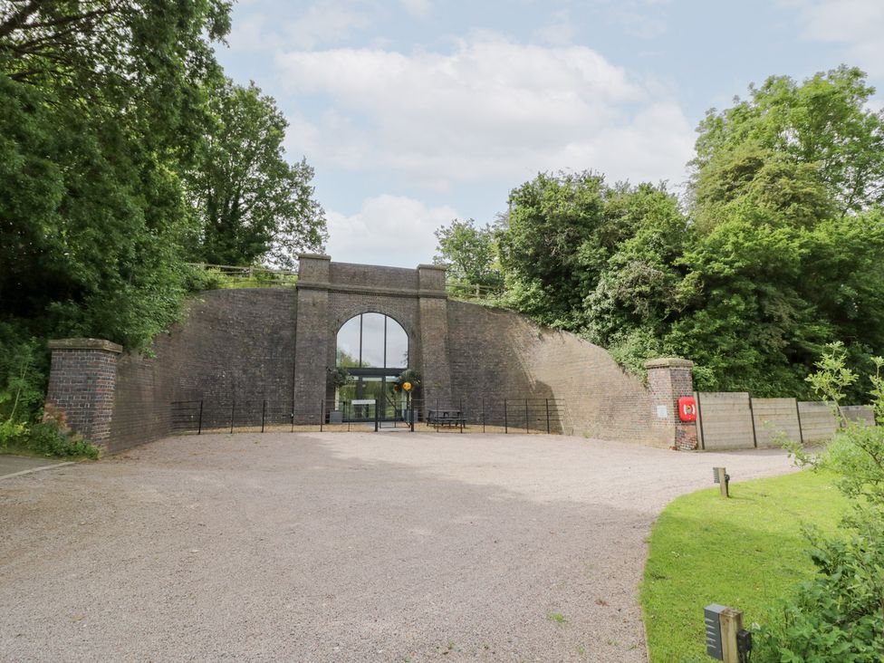 An outdoor space with a brick wall and gate at The Tunnel at Bridge Lake Farm and Fishery in Chacombe