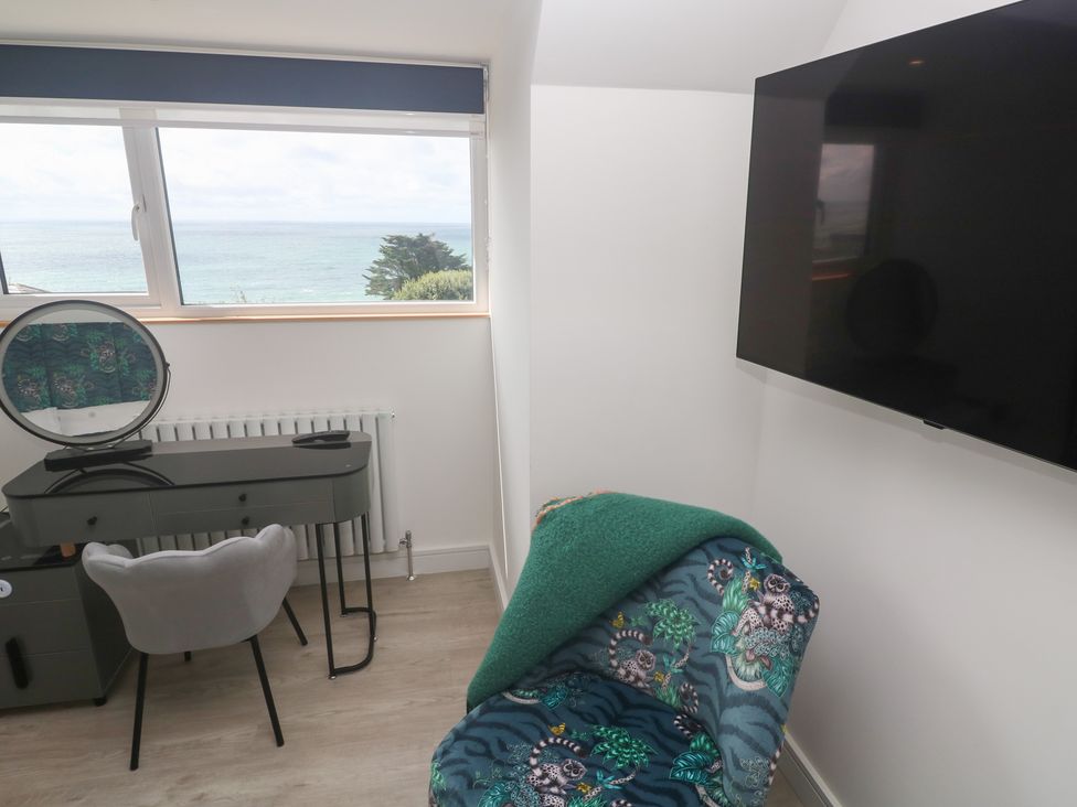 A bedroom with a desk, chair and tv at Shearwater
