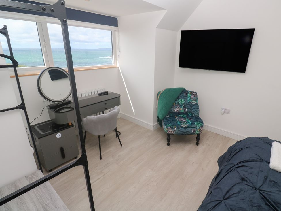 A bedroom with a desk, chair, and TV at Shearwater
