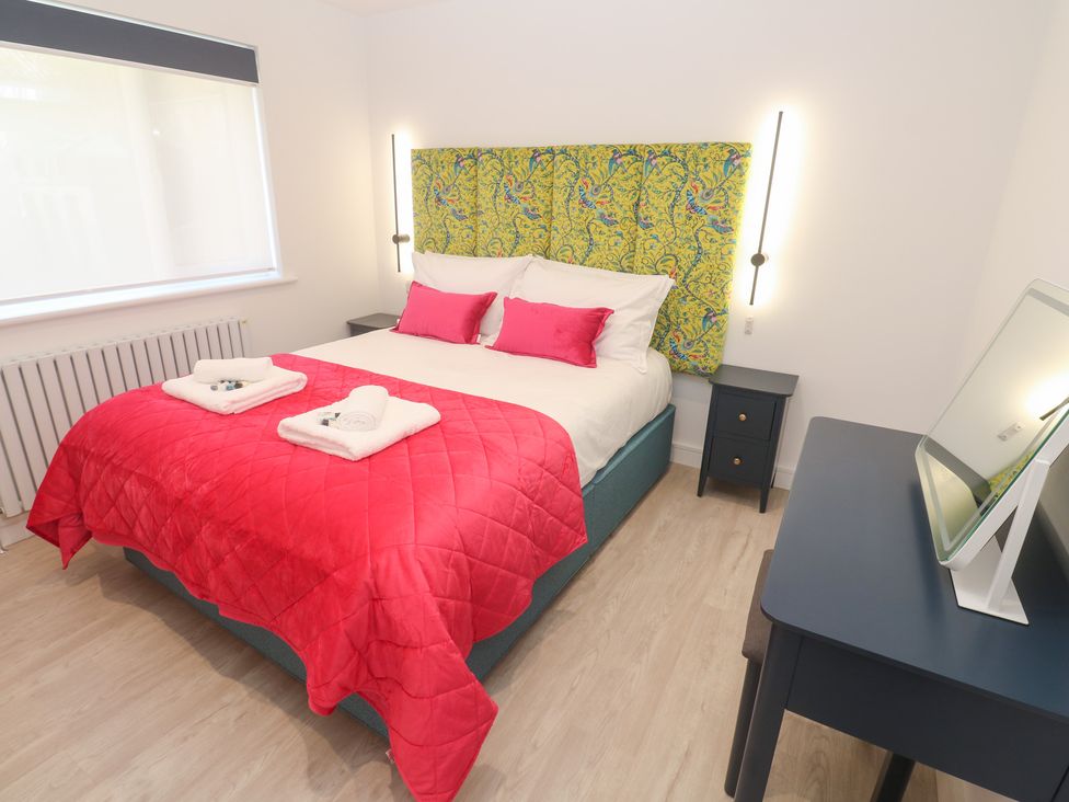 A bedroom with a bed and nightstand at Shearwater 