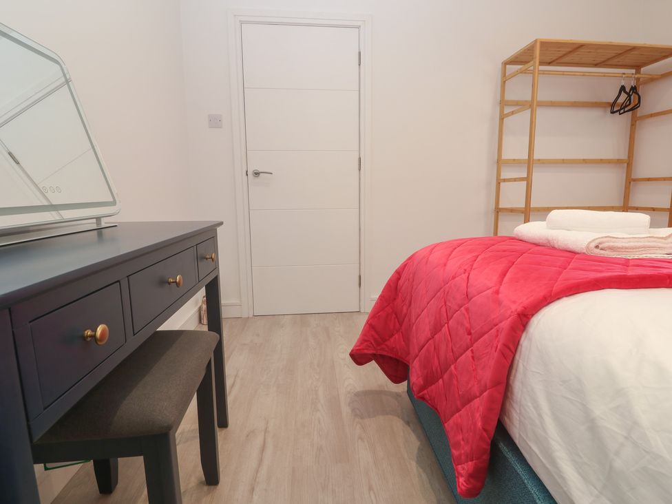 A bedroom with a bed and a dressing table at Shearwater 