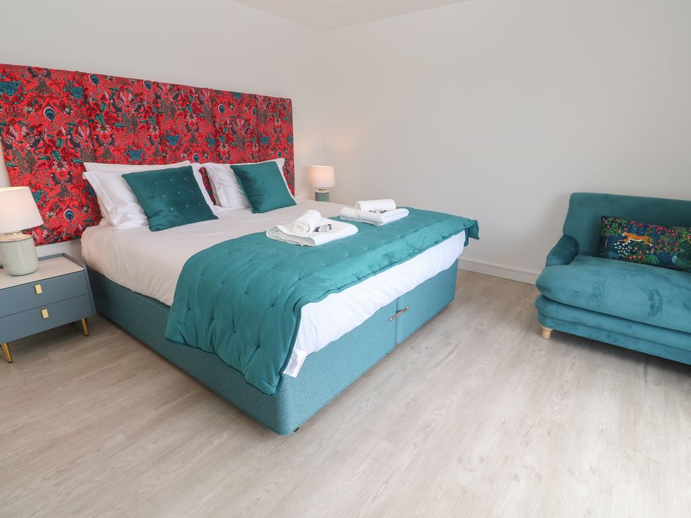 A bedroom with a bed, bedside tables, and a sofa at Shearwater