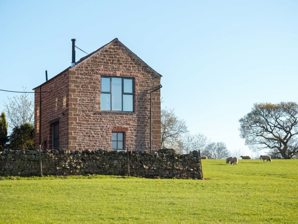 A house with a stone wall and sheep in the field at Shepherds View in Dufton, near Appleby-in-Westmorland