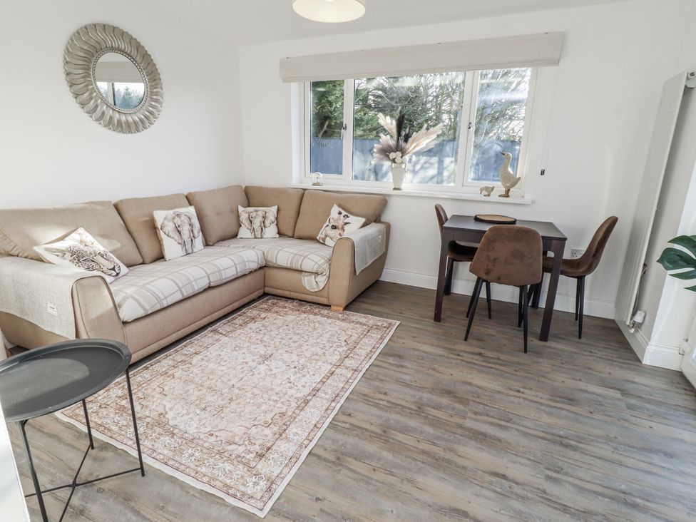A living room with a sofa and dining table at Old Colliery Cottage in Shilbottle