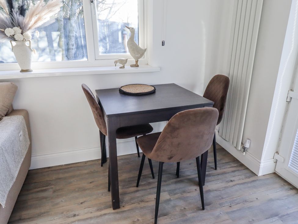 A dining room with a table and chairs at Old Colliery Cottage in Shilbottle