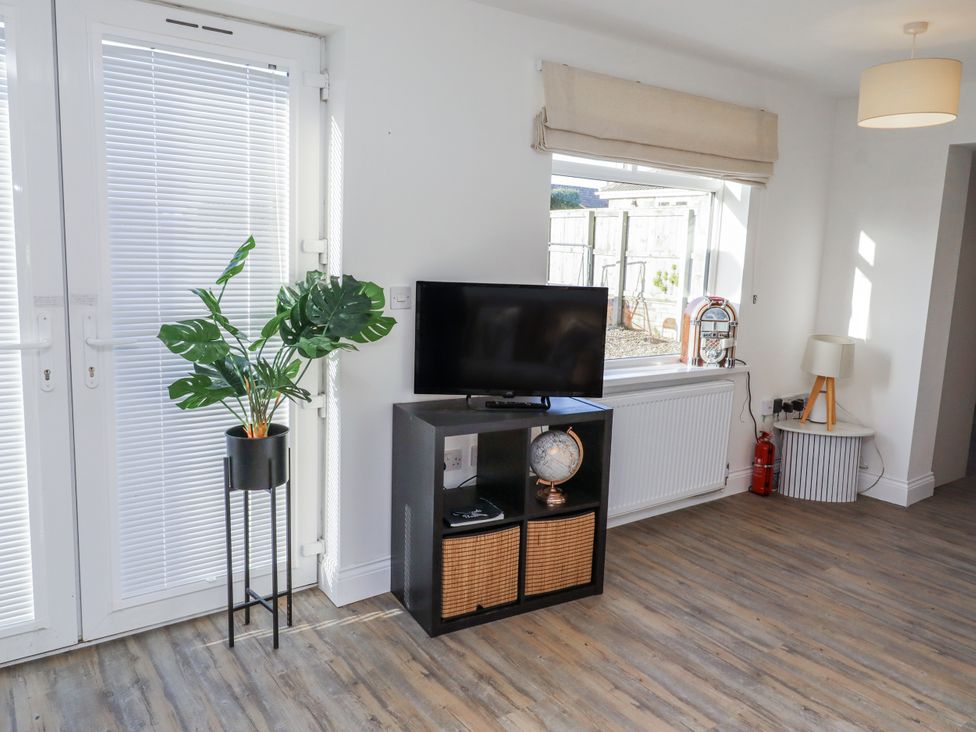 A living room with a television and a plant at Old Colliery Cottage in Shilbottle