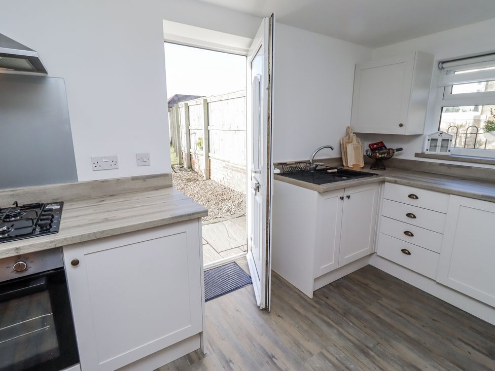 A kitchen with cabinets and a gas stove at Old Colliery Cottage in Shilbottle